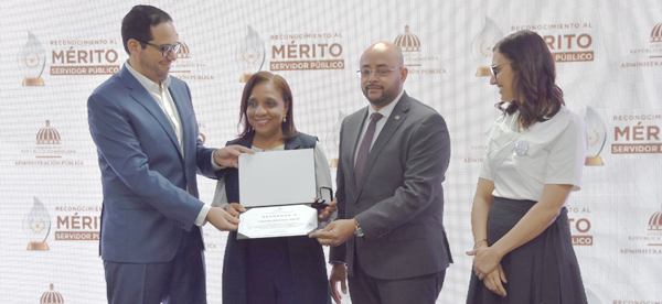 El Ministerio de la Administración Pública, en colaboración de la Dirección General de Jubilaciones y Pensiones a Cargo del Estado (DGJP), otorgó el “Reconocimiento al Mérito Servidor Público" a Lisette Sánchez Abad, quien ha dedicado 33 años ininterrumpidos al servicio público. El director general de Jubilaciones y Pensiones, licenciado Juan Rosa, describió a la colaboradora Sánchez Abad, abogada de Autoseguro de la DGJP, como un ejemplo a seguir, por su excepcional desempeño, dedicación y compromiso al servicio del Estado. La señora Sánchez, recibió el reconocimiento de la mano del ministro del MAP, Sigmund Freund, junto al subdirector general de la DGJP, licenciado Félix Joel Almonte, quien representó al director general, Juan Rosa, acompañado de la directora de Recursos Humanos, Santa Ortiz. Durante la ceremonia, celebrada en el salón de eventos del MAP, el ministro Freund felicitó a todos los homenajeados, resaltando compromiso y excelencia al servicio del Estado. El evento, realizado en el marco del Día del Servidor Público, instituido por la Ley 302 cada 25 de enero, contó con la presencia, de destacadas personalidades, entre ellas Milagros Ortiz Bosch, directora de Ética e Integridad Gubernamental, y Rómulo Arias Moscat, Contador General de la República. También participaron ministros, viceministros, directores generales y colaboradores de diversas instituciones.