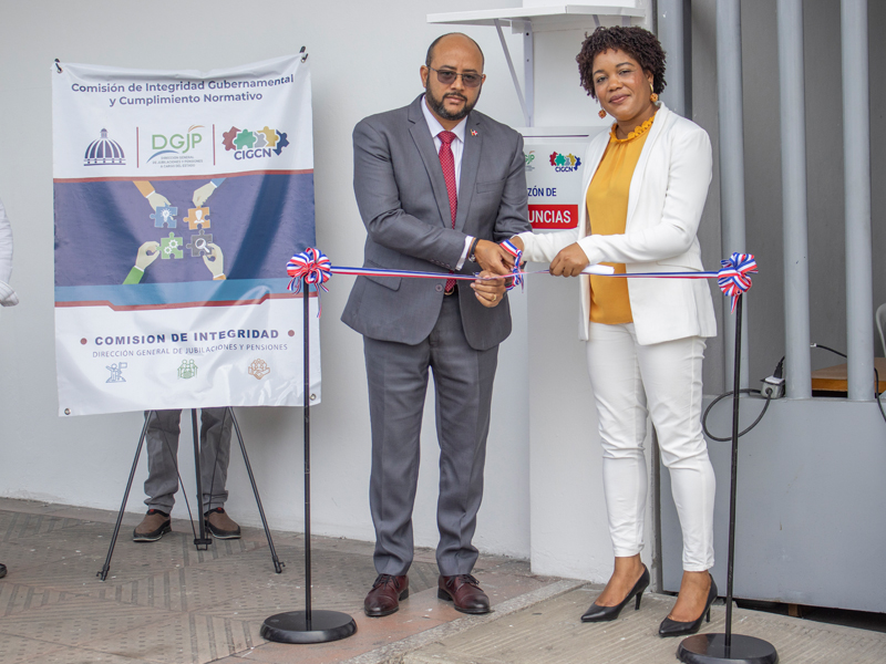 La Comisión de Integridad Gubernamental y Cumplimiento Normativo (CIGCN) de la Dirección General de Jubilaciones y Pensiones a Cargo del Estado, (DGJP), inauguró hoy el Buzón Físico de Denuncias Ciudadanas, con el objetivo de reforzar el compromiso institucional con la transparencia, la ética e integridad y de generar confianza entre los usuarios, pensionados y ciudadanos. El acto inaugural del Buzón fue llevado a cabo en explanada frontal de la sede principal de la DGJP con la presencia del subdirector Felix Joel Almonte y Carmen Celeste Mañon, coordinadora general de la CIGCN, quienes tuvieron a cargo el corte de cinta. El subdirector Felix Joel Almonte, en representación del director general Juan Rosa, tuvo a su cargo el discurso central del evento, quien señaló que más que cumplir con una normativa, se habilita un canal seguro, confidencial y accesible para que cualquier ciudadano pueda denunciar actos de corrupción, negligencia o cualquier irregularidad,” dijo además que, “Este acto refleja nuestro compromiso con los principios de ética, integridad y rendición de cuentas” La Comisión de Integridad Gubernamental y Cumplimiento Normativo (CIGCN) de la Dirección General de Jubilaciones y Pensiones a Cargo del Estado, (DGJP), inauguró hoy el Buzón Físico de Denuncias Ciudadanas, con el objetivo de reforzar el compromiso institucional con la transparencia, la ética e integridad y de generar confianza entre los usuarios, pensionados y ciudadanos. El acto inaugural del Buzón fue llevado a cabo en explanada frontal de la sede principal de la DGJP con la presencia del subdirector Felix Joel Almonte y Carmen Celeste Mañon, coordinadora general de la CIGCN, quienes tuvieron a cargo el corte de cinta. El subdirector Felix Joel Almonte, en representación del director general Juan Rosa, tuvo a su cargo el discurso central del evento, quien señaló que más que cumplir con una normativa, se habilita un canal seguro, confidencial y accesible para que cualquier ciudadano pueda denunciar actos de corrupción, negligencia o cualquier irregularidad,” dijo además que, “Este acto refleja nuestro compromiso con los principios de ética, integridad y rendición de cuentas”